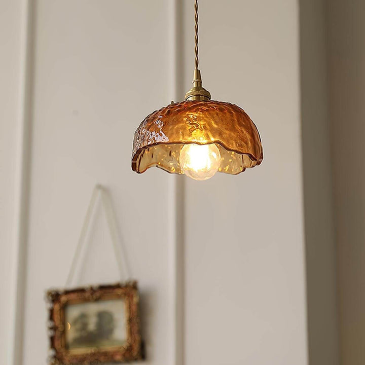 Rustik brun glas pendellampe placeret på et bord
