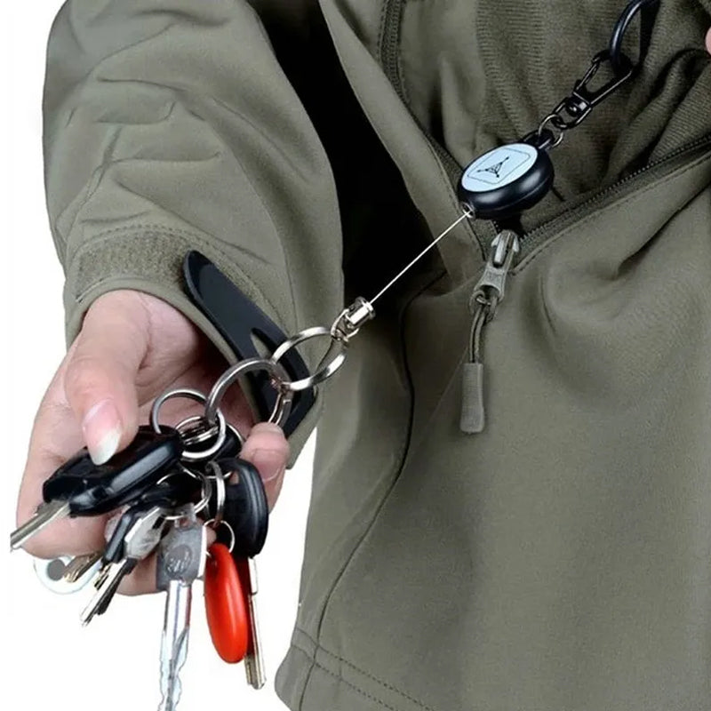 Nøglering med sort design og metallisk udtrækkeligt kabel, et praktisk og holdbart tilbehør.
