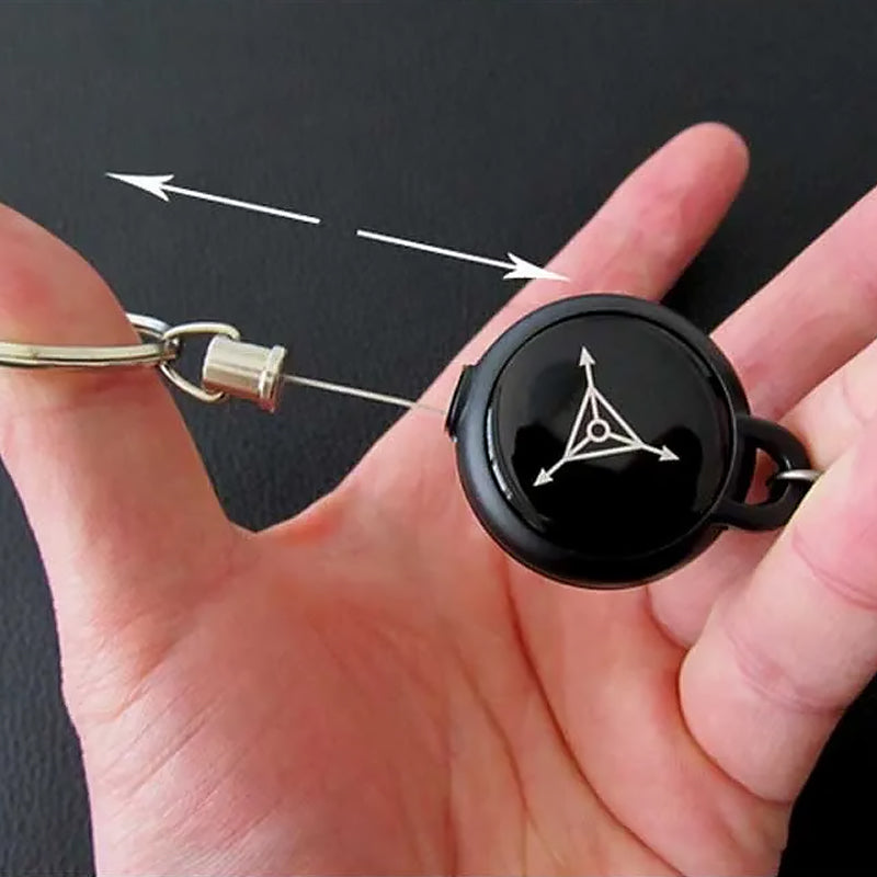 Nøglering med sort design og metallisk udtrækkeligt kabel, et praktisk og holdbart tilbehør.
