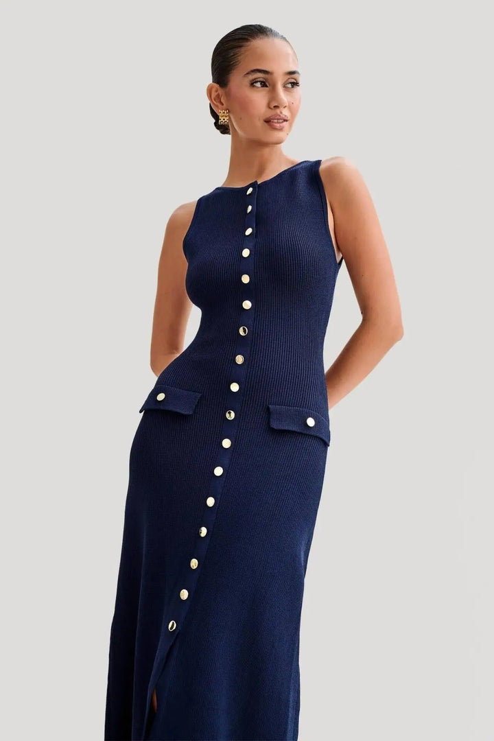 Elegant damekjole uden ærmer i strik, ensfarvet, med knapper foran, kropsnær silhuet, blødt materiale.