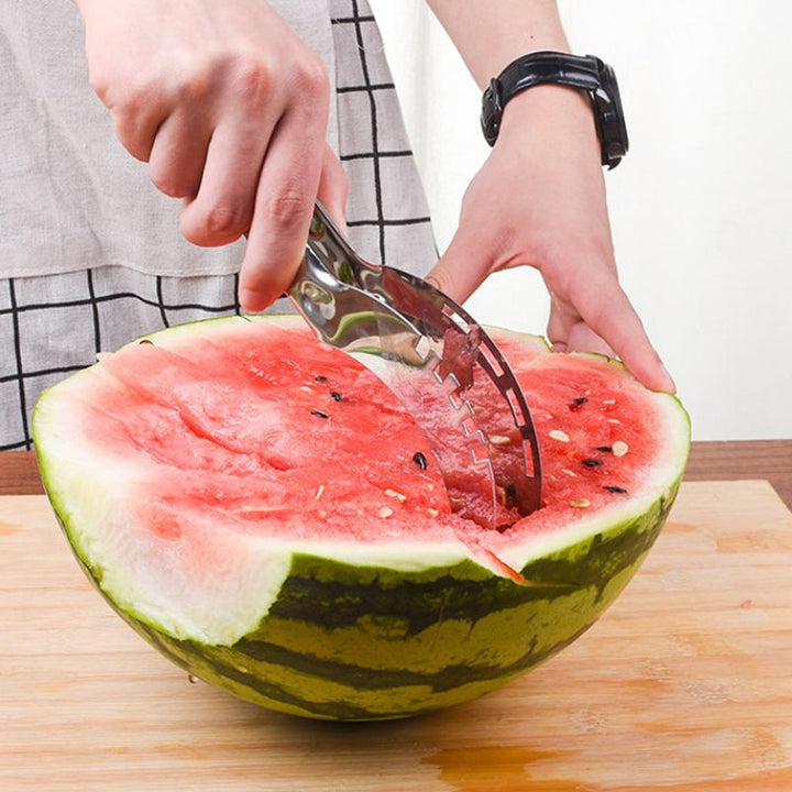 Multifunktionel vandmelon skærer i sølv og grøn, lavet af rustfrit stål med sikkerhedshåndtag, moderne design til køkkenet.