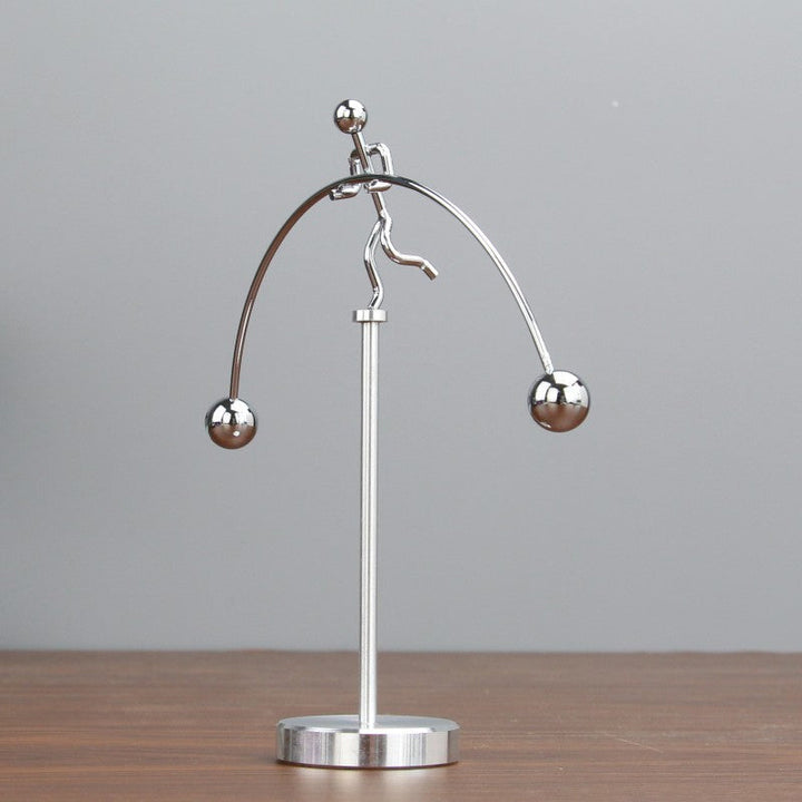 Moderne sølvfarvet metaldekoration med balance mekanisme, elegant tilføjelse til skrivebord eller soveværelse.