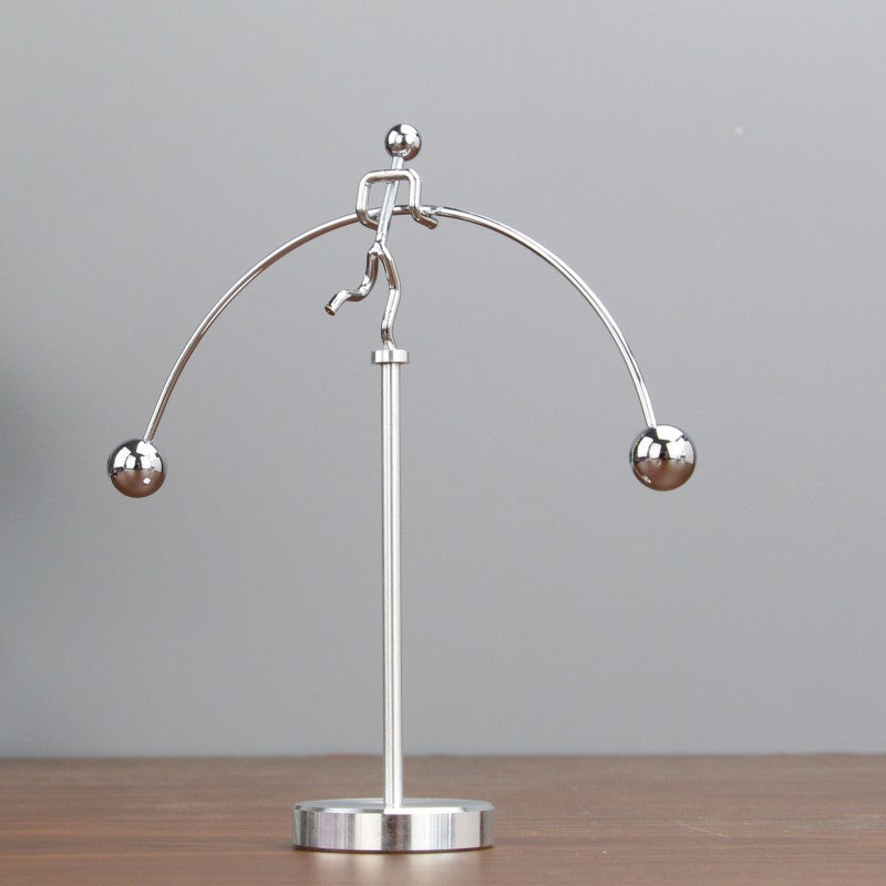 Moderne sølvfarvet metaldekoration med balance mekanisme, elegant tilføjelse til skrivebord eller soveværelse.