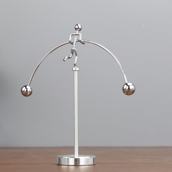 Moderne sølvfarvet metaldekoration med balance mekanisme, elegant tilføjelse til skrivebord eller soveværelse.