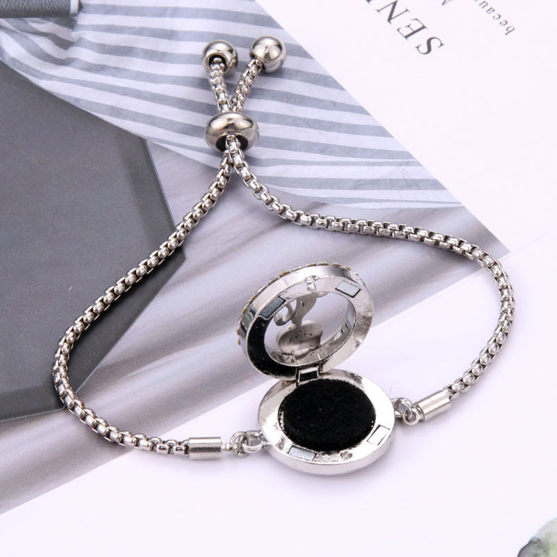 Elegant sølvfarvet armbånd i titaniumstål med et stilfuldt design og duftabsorberende filtpuder.