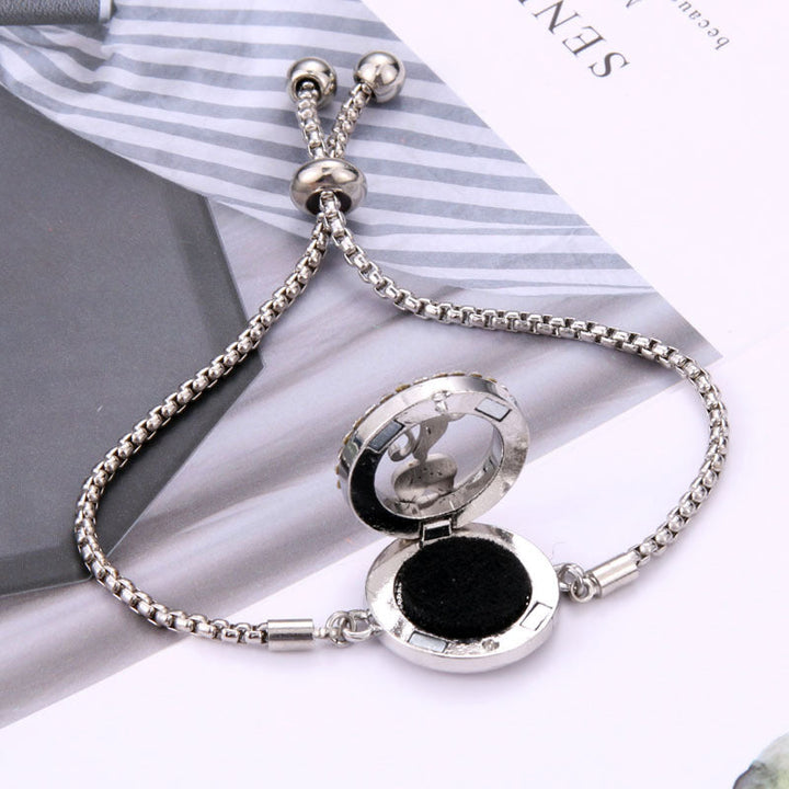 Elegant sølvfarvet armbånd i titaniumstål med et stilfuldt design og duftabsorberende filtpuder.