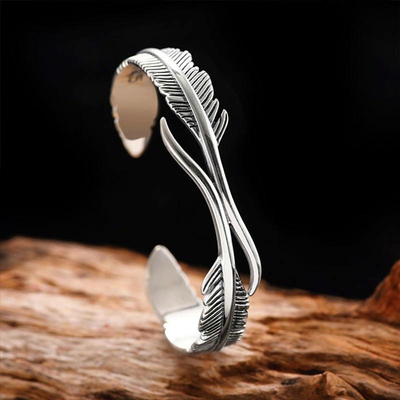 Sølvbelagt dame armbånd med fjerdesign, let og elegant tilbehør der symboliserer beskyttelse og frihed.