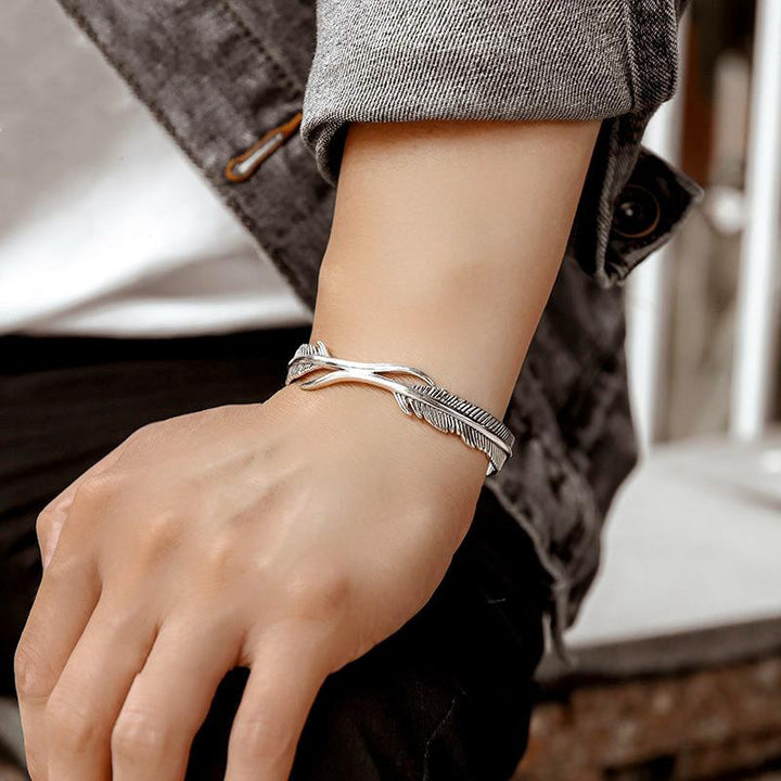 Sølvbelagt dame armbånd med fjerdesign, let og elegant tilbehør der symboliserer beskyttelse og frihed.