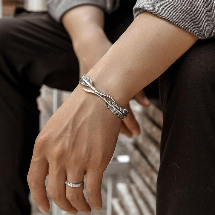 Sølvbelagt dame armbånd med fjerdesign, let og elegant tilbehør der symboliserer beskyttelse og frihed.