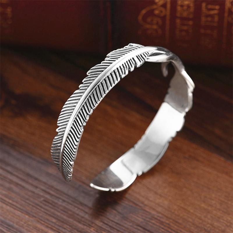 Sølvbelagt dame armbånd med fjerdesign, let og elegant tilbehør der symboliserer beskyttelse og frihed.