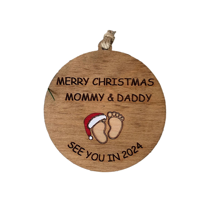 Julepynt til vordende forældre, indgraveret med teksten 'Merry Christmas Mommy and Daddy See You in 2024', bøgetræ