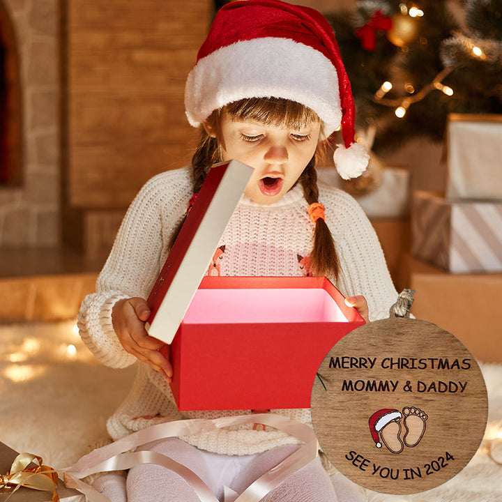 Julepynt til vordende forældre, indgraveret med teksten 'Merry Christmas Mommy and Daddy See You in 2024', bøgetræ
