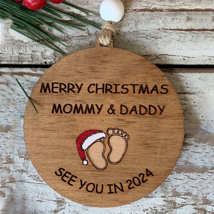Julepynt til vordende forældre, indgraveret med teksten 'Merry Christmas Mommy and Daddy See You in 2024', bøgetræ