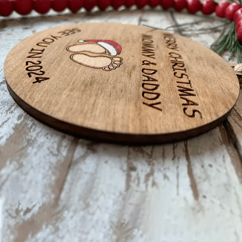 Julepynt til vordende forældre, indgraveret med teksten 'Merry Christmas Mommy and Daddy See You in 2024', bøgetræ