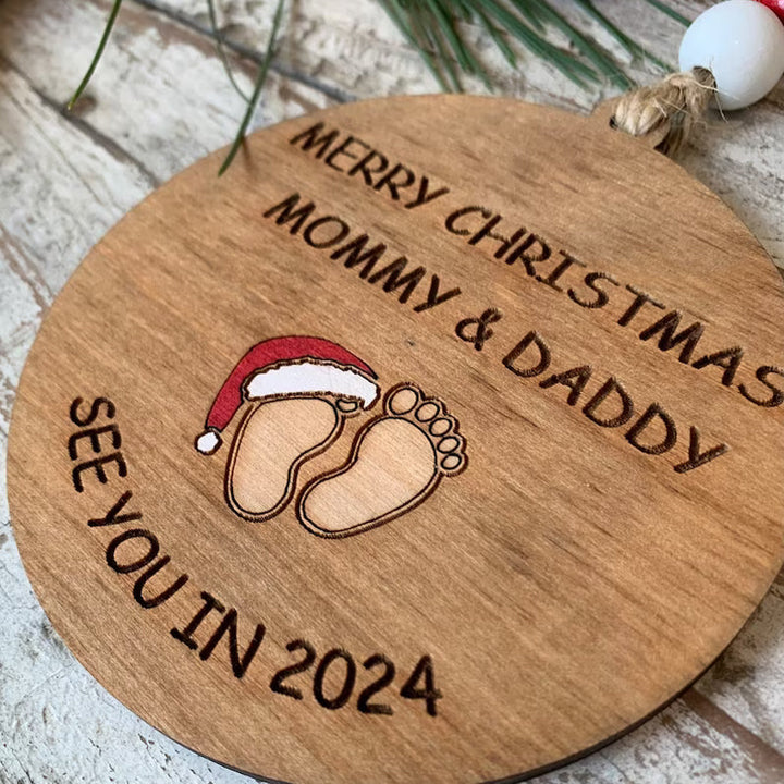 Julepynt til vordende forældre, indgraveret med teksten 'Merry Christmas Mommy and Daddy See You in 2024', bøgetræ
