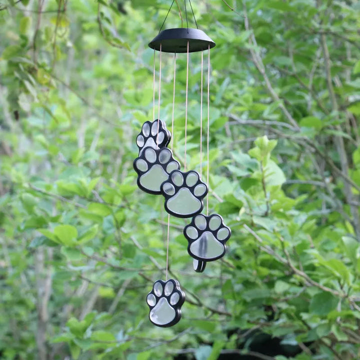 Bjørnefod formet solcelledrømmefanger gløder flerfarvet, perfekt til haven eller terrassen.