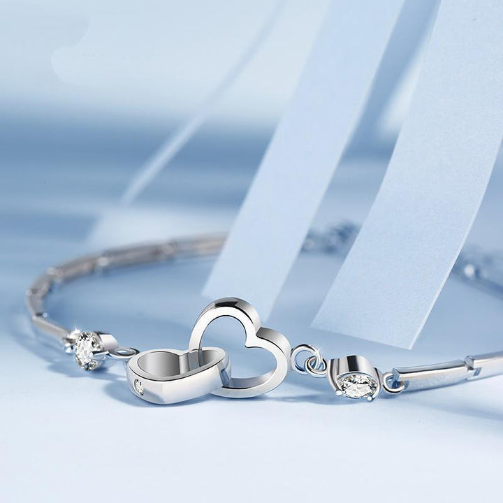 Skinnende hjertearmbånd med zirkoner, feminint og elegant tilbehør, funklende zirkonudsmykning fremhæver hjerteformen.