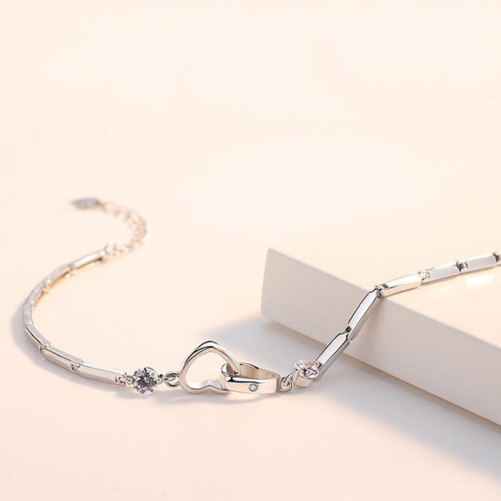 Skinnende hjertearmbånd med zirkoner, feminint og elegant tilbehør, funklende zirkonudsmykning fremhæver hjerteformen.