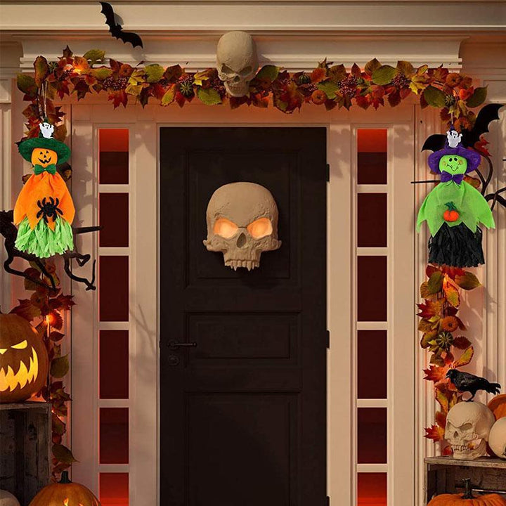 "Kolme erilaista roikkuvaa Halloween-kummitusta; noidanhattu, hymyilevät kasvot, kurpitsat ja hämähäkit."