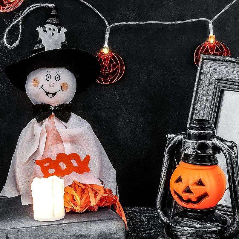 "Kolme erilaista roikkuvaa Halloween-kummitusta; noidanhattu, hymyilevät kasvot, kurpitsat ja hämähäkit."