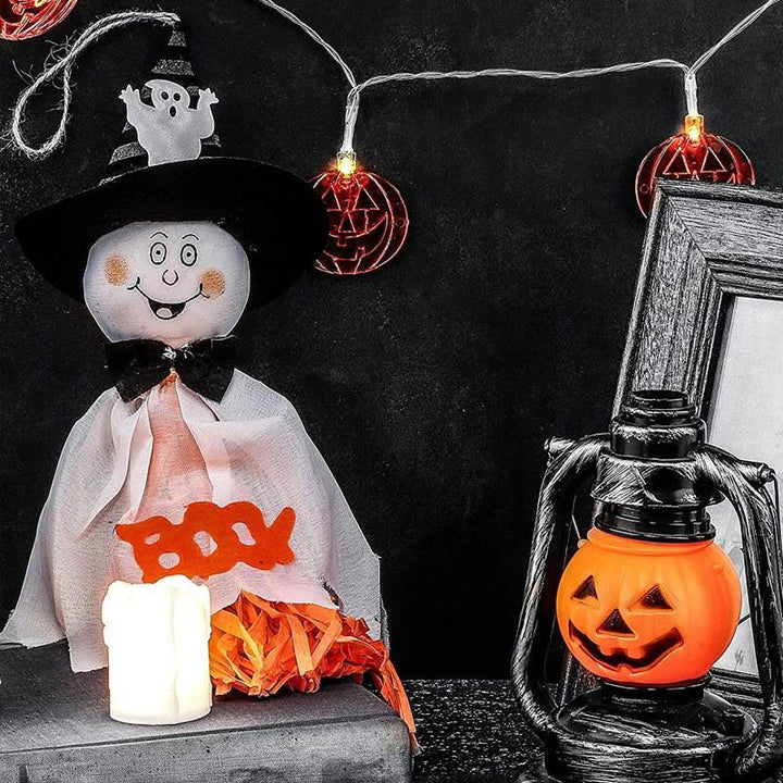 "Kolme erilaista roikkuvaa Halloween-kummitusta; noidanhattu, hymyilevät kasvot, kurpitsat ja hämähäkit."