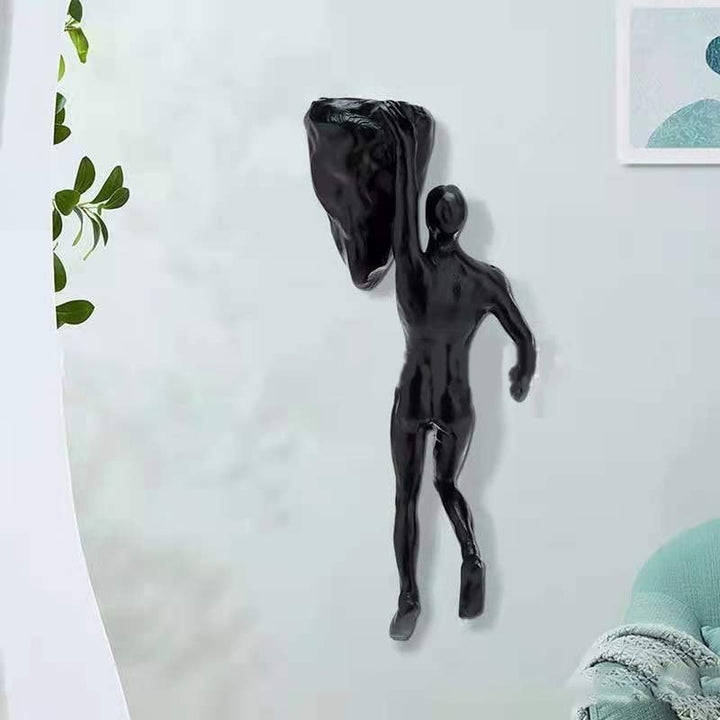 3D vægklatrefigur, sort figur der klatrer på en lodret overflade, moderne boligdekoration.