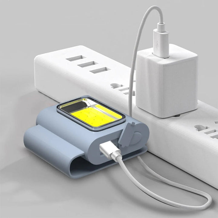 Kompakt grå bærbar LED-lommelygte, magnetisk beslag, flere lysindstillinger, USB-genopladelig, IPX4 vandtæt.
