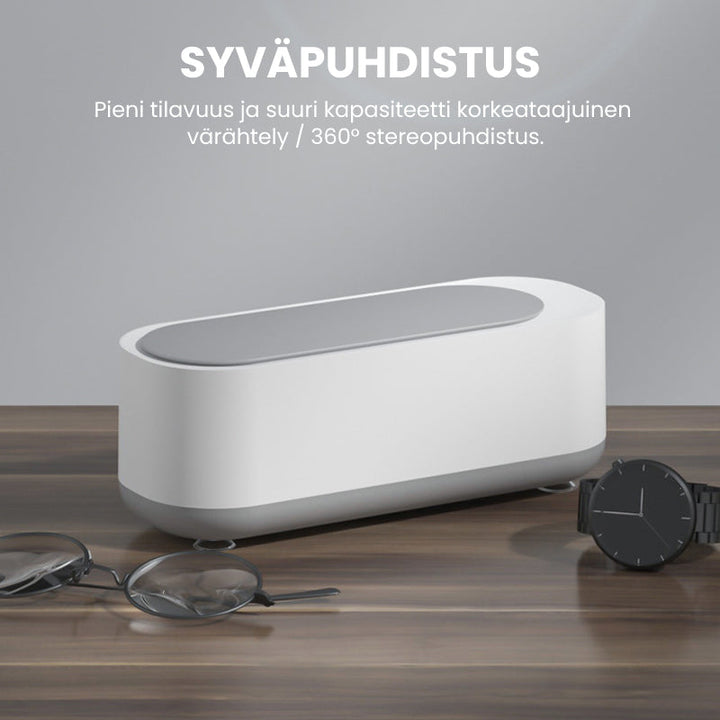 Kompakt hvid-grå ultralyd renser til dybderensning; fjerner snavs fra briller og smykker med højfrekvent vibration