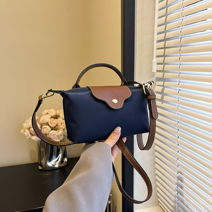 Kompakt farveblok crossbody-taske til damer i nuancer af blå, sort og khaki; en praktisk og stilfuld accessory.