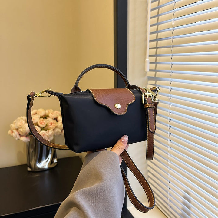 Kompakt farveblok crossbody-taske til damer i nuancer af blå, sort og khaki; en praktisk og stilfuld accessory.