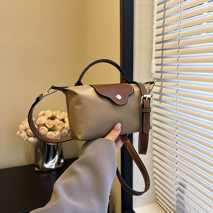 Kompakt farveblok crossbody-taske til damer i nuancer af blå, sort og khaki; en praktisk og stilfuld accessory.