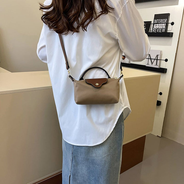 Kompakt farveblok crossbody-taske til damer i nuancer af blå, sort og khaki; en praktisk og stilfuld accessory.