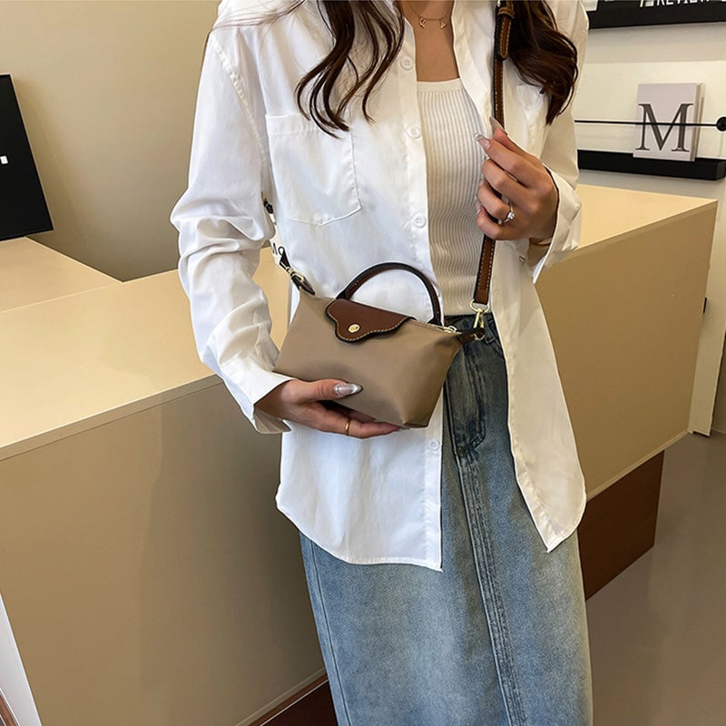 Kompakt farveblok crossbody-taske til damer i nuancer af blå, sort og khaki; en praktisk og stilfuld accessory.