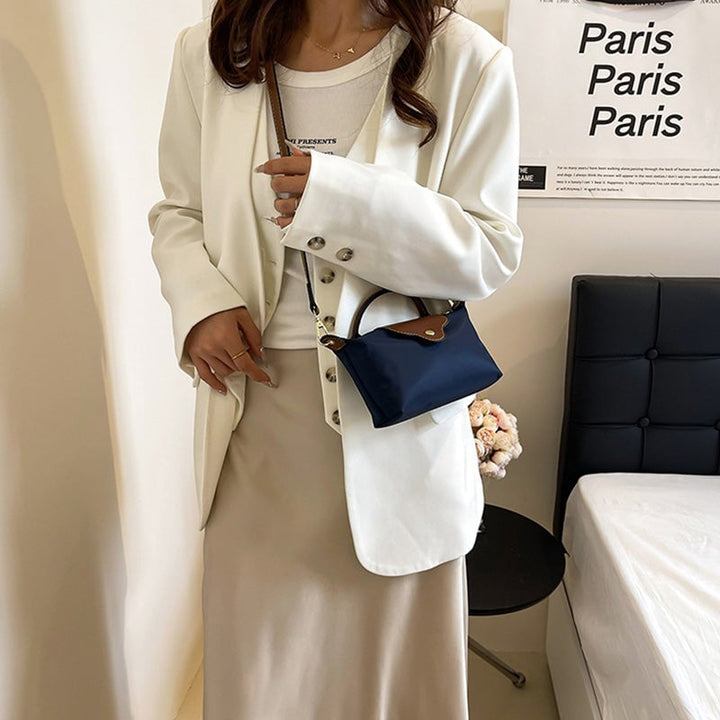 Kompakt farveblok crossbody-taske til damer i nuancer af blå, sort og khaki; en praktisk og stilfuld accessory.