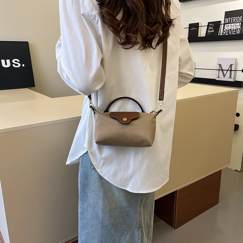 Kompakt farveblok crossbody-taske til damer i nuancer af blå, sort og khaki; en praktisk og stilfuld accessory.