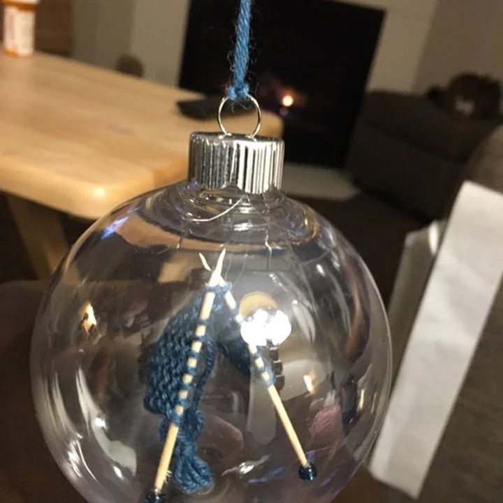 Håndlavet juledekoration til strikkere i en akrylkugle med strikkepinde, fås i forskellige farver, diameter 8,3 cm.