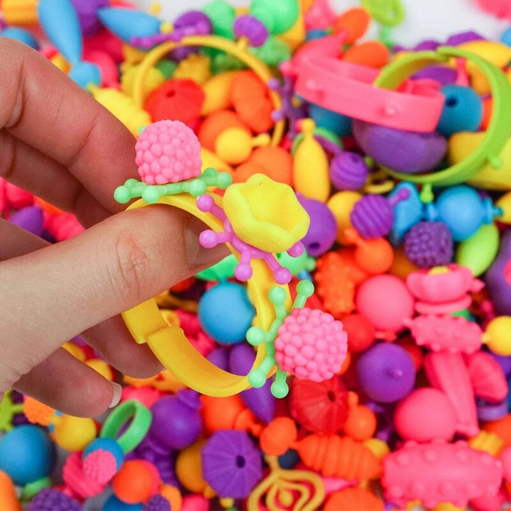 Børns Kreative Perlesæt: Farverige plastikperler, træarmbånd. Kunst, kreativitet og sikker leg for børn.