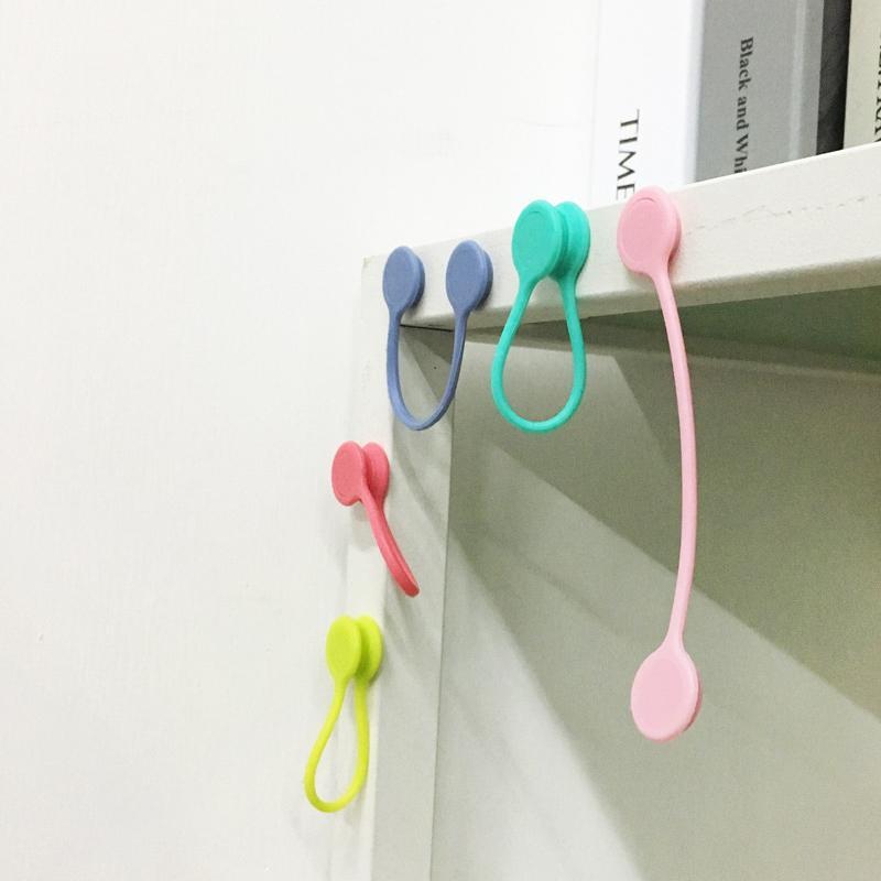 Magneettiset kaapelisiteet: värikkäät silikonipidikkeet, minimalistinen muotoilu, vahva magneettikiinnitys.