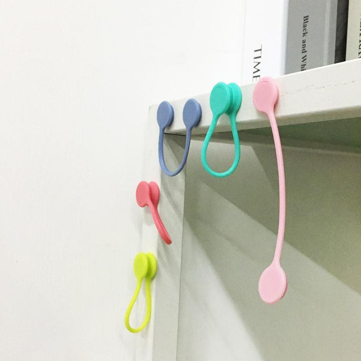 Magneettiset kaapelisiteet: värikkäät silikonipidikkeet, minimalistinen muotoilu, vahva magneettikiinnitys.