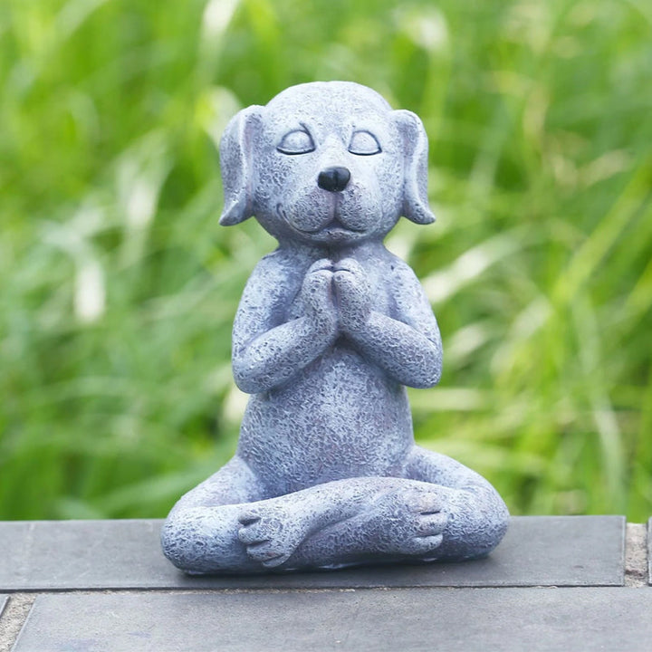 Meditativ hund harpiks havepynt, siddende med krydsede ben i en fredfyldt positur, velegnet til indendørs og udendørs brug.