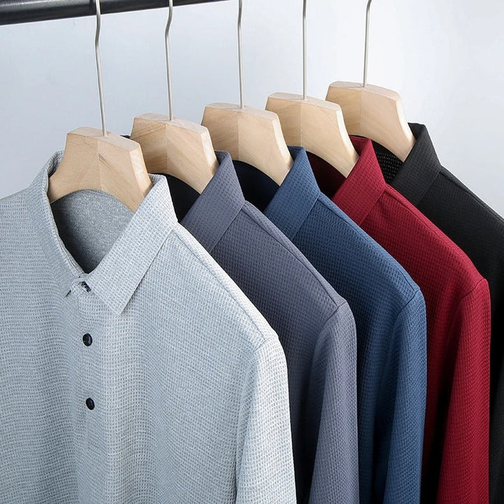 "Miesten business casual poolopaita, pitkät hihat, pehmeä ja hengittävä kangas, räätälöity istuvuus, harmaa sävy."