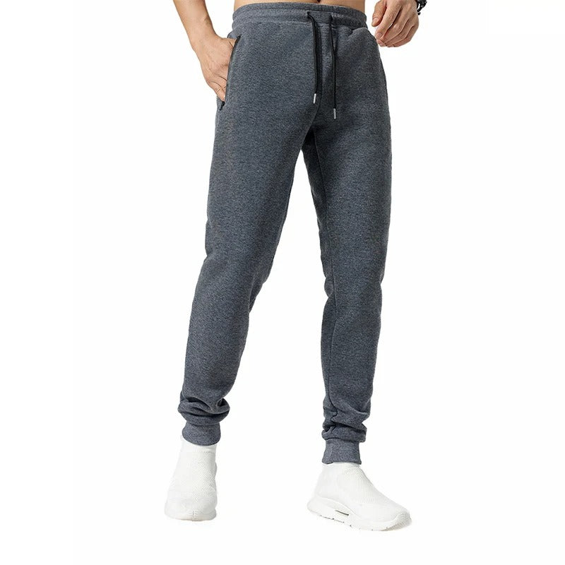 Miesten harmaat loose fit treenijoggerit, joustava vyötärö, vetoketjulliset taskut, hengittävä ja pehmeä kangas.