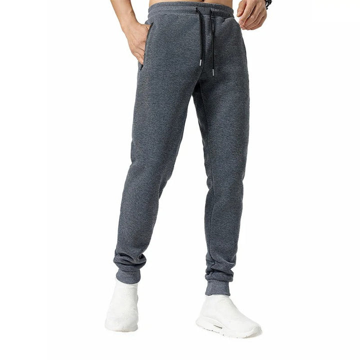 Miesten harmaat loose fit treenijoggerit, joustava vyötärö, vetoketjulliset taskut, hengittävä ja pehmeä kangas.