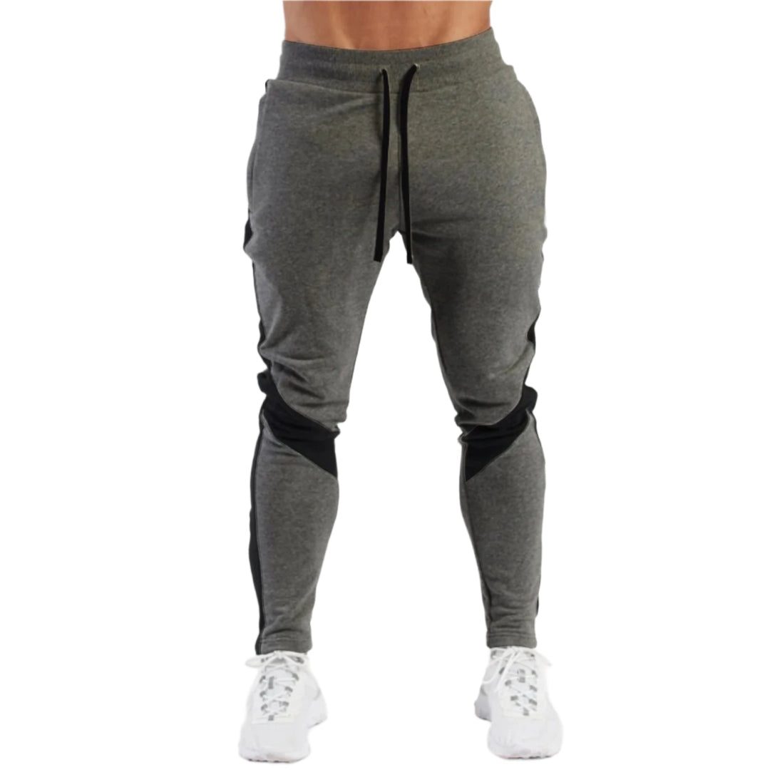 "Miesten hengittävät fitness joggersit, joustava istuvuus, harmaa väri, taskut, kiristysnauha vyötäröllä, moderni design."