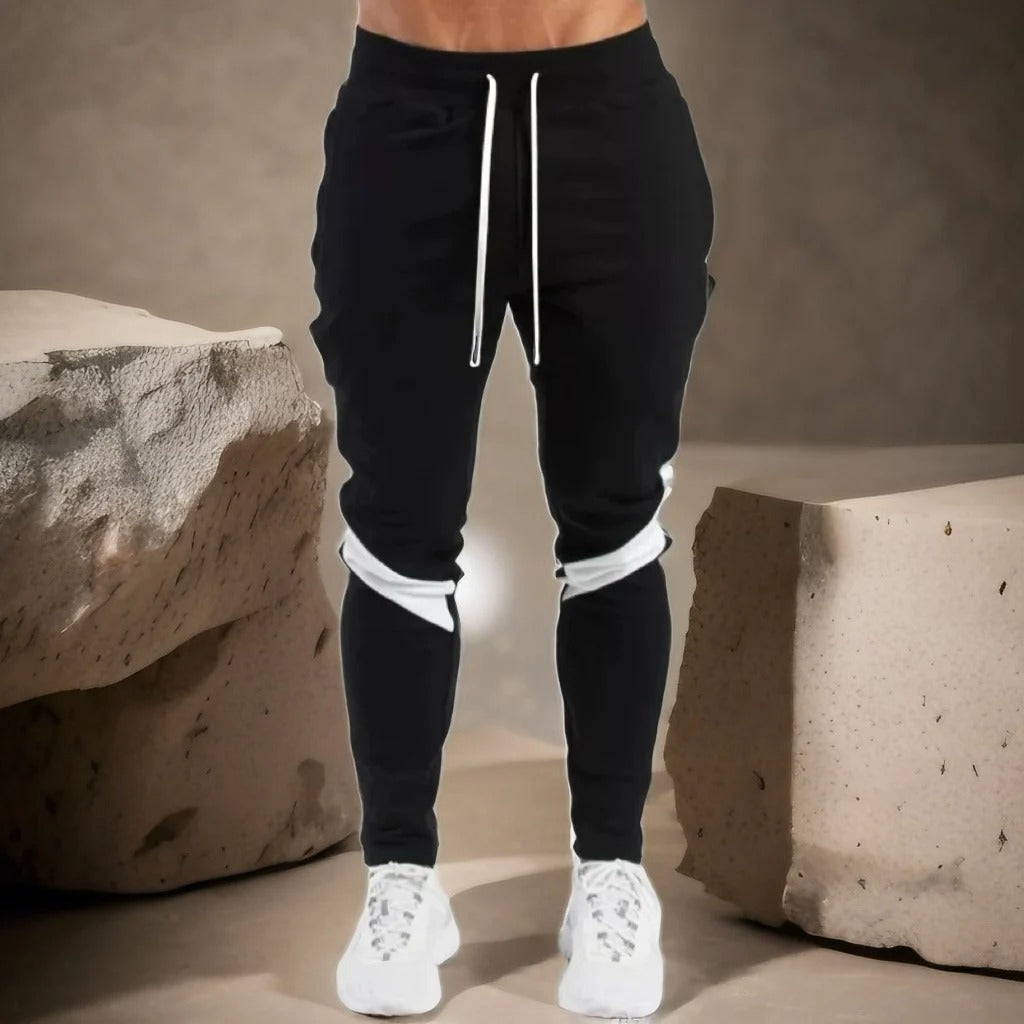 "Miesten hengittävät fitness joggersit, joustava istuvuus, harmaa väri, taskut, kiristysnauha vyötäröllä, moderni design."