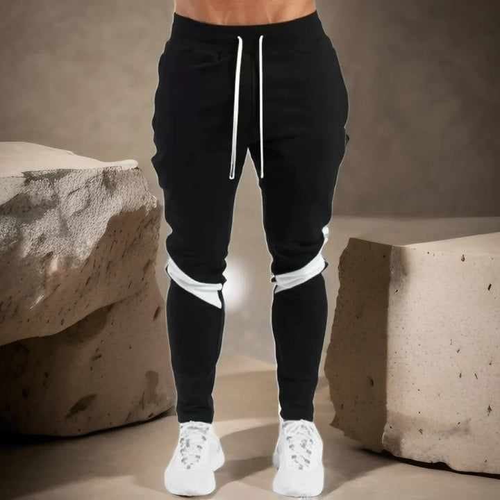"Miesten hengittävät fitness joggersit, joustava istuvuus, harmaa väri, taskut, kiristysnauha vyötäröllä, moderni design."