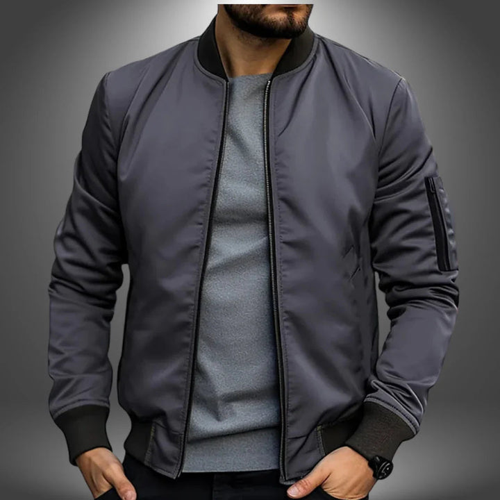 "Miesten kevyt tuulitakkityylinen bomber-takki, minimalistinen design, ribbaus hihansuissa, vetoketjullinen tasku"