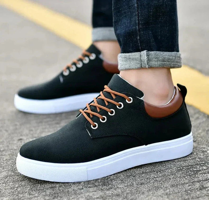 "Miesten tyylikkäät mustat sneakersit ergonomisella pohjalla, joka yhdistää mukavuuden ja muodin arkeen ja juhlaan."