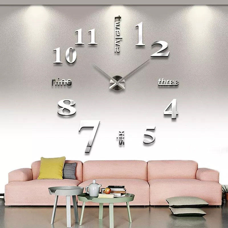 Moderne akryl DIY vægur i sølv, stort minimalistisk design, monteret på hvid væg, stille mekanisme.