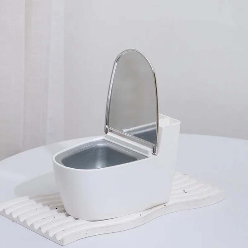 Moderne sølv-guld-hvid toilet askebæger, der ligner et miniaturetoilet, lavet af holdbart ABS-plast.